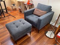 Armchair and ottoman angled left-front view on hardwood floor