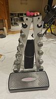 Front view of full assembly including rack, dumbbells, stepper and mat