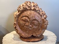 Front view of the carved sun face on base
