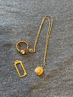 Overview of ring, rectangular pendant with small stone, and chain necklace with shell pendant.