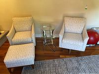 Two swivel chairs and matching ottoman grouped in living room