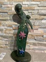 Front view of entire sculpture showing sea otter perched on jade slab base with starfish accents