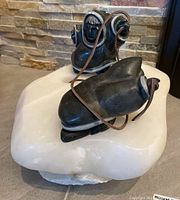 Overall view of dark green soapstone figures and white soapstone base with carved fish