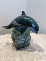 Front view of jade killer whale sculpture atop rough jade base