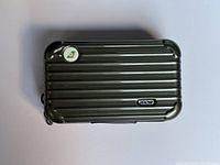 Top view of olive green hard shell toiletries case showing ribbed design and metallic Rimowa logo