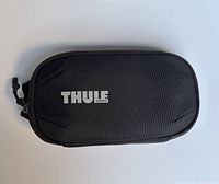 Front view of black Thule toiletries bag showing overall design and logo