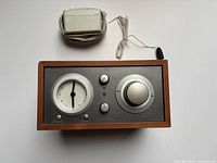 Top-down view of Tivoli Audio Model Three clock radio with its power adapter shown above the unit.