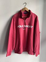 Front view of red Polo Sport Ralph Lauren sweatshirt with quarter zip, logo, and flag graphic.