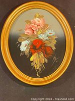Full view of floral oil painting with visible artist signature and wooden oval frame. Shows color gradients and flower details.