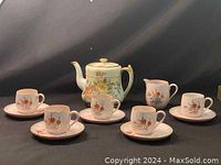 Full tea set including teapot, creamer, five cups and five saucers photographed together to show complete set composition and design.