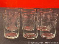 Front view of the six vintage clear glasses showing different etched floral and grape designs.