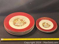 Stack of six dinner plates and four side plates with a measuring tape showing size