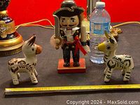 Front view of the nutcracker and two porcelain horses with measuring tape