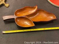 Top view of the wooden serving tray shaped like a leaf with three compartments, a measuring tape beside showing size.
