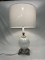 Full view of lamp with attached off-white drum shade showing lamp details and cord