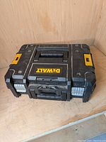 Dewalt TSTAK II flat top toolbox closed, showing overall shape, handle, and Dewalt branding label on top.