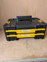 Front view of black and yellow Dewalt TSTAK IV drawer unit with two drawers labeled screws and nails.