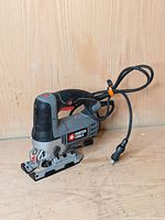 Side view of Porter-Cable jigsaw showing ergonomic handle, red trigger, and metal base plate.