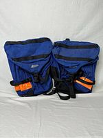 Front view of the pair of blue MEC bicycle panniers showing overall condition and orange reflectors.