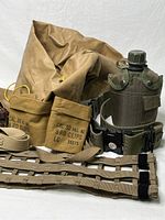 Photo showing canvas bag, canteen with cover, web belt, leg straps, and two ammo pouches