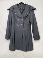 Full view of the gray peacoat button-up jacket on a hanger in good condition with exaggerated collar and long sleeves.