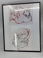 Front view of the first framed print featuring two Sailor Moon character sketches, one with light hair and one with dark hair, with black plastic trim frame.