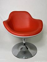 Front view of red lounge chair on chrome pedestal base