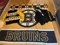 Boston Bruins large flag spread out on floor with light-up sweater and raincoat laid on top