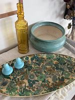 Photo showing all four items together: floral tray, blue salt and pepper shakers, yellow glass bottle, and blue-green ceramic dish