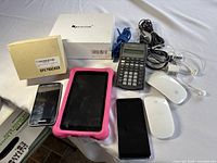 Arrangement of most items in separate view showing tablet, phones, scientific calculator, mice, cables, GPS tracker box, and wireless microphone system