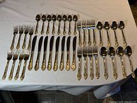Full layout of all 40 pieces of the Hampton Silversmiths silverware set including forks, knives, tablespoons, and teaspoons laid out on a table.