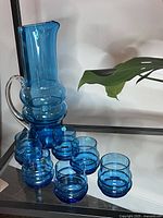 Photo showing nine-piece blue blown glass bar set including a pitcher and eight tumblers.