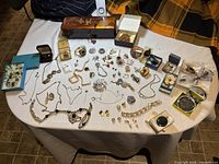 Full view of the collection on a table showing diverse vintage jewelry pieces and the Laqueur lacquered box.