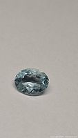 Oval cut Brazilian aquamarine gemstone showing faceted top view and clarity.