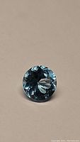 Front view of a round faceted Swiss blue topaz gemstone showing depth of color and clarity.