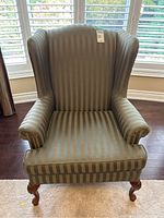 Front view showing striped upholstery and curved wooden legs