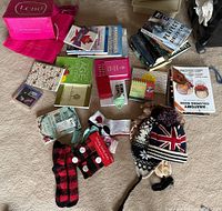 Photo of assorted books, ladies socks, winter toques, travel jewelry box, and small items spread on floor