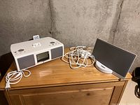 Wide shot showing Bose SoundDock and TEAC L200i radio side by side on wooden surface.