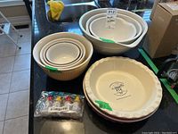 Photo showing nested ceramic mixing bowls and pie plates, along with mini condiment containers grouped in front.
