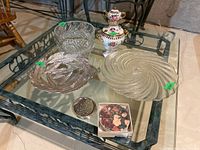 Group image showing all items together on a glass table - crystal bowl, metal bowl, glass cake plate, mini samovar vase, and coasters.