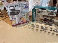 Photo of Jack LaLanne Power Juicer Elite box, Cuisinart Griddler Gourmet box, and chrome chafing dish rack on a table.