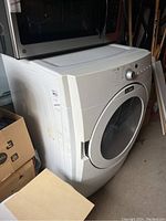Front angle view of white Maytag dryer with control panel and transparent door showing minor surface scuffs.