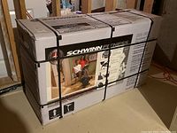 Image of the unopened box of Schwinn Fitness SRB-1800 recumbent bike, showing brand and model number on packaging along with marketing images of the bike in use.