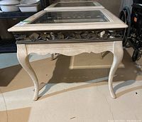 Front-side view of the wood side table showing curved legs and beveled glass top with metal insert.
