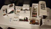 Wide view of all Department 56 Christmas in the City items in original boxes arranged on a table.
