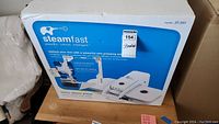Box of Steamfast SP-660 fabric steam press showing front, brand, and product image.