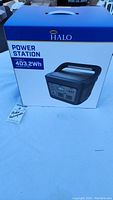 Sealed unopened blue and white box with Halo Power Station branding and handle visible