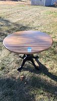 Photo showing the round wooden table top with a natural wood finish in outdoor light.