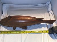 Side view of wooden fish decoy showing full length with measuring tape indicating approximately 14 inches long.