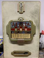 Front metal panel of Exacta slot machine with coin slot, start button, and viewing window for reels displaying numbers 6, 4, and Free Spiel.